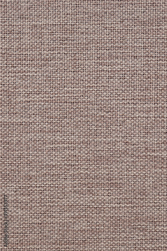 Close-up of woven surface. Pale brown tinted fabric background or wallpaper. Light vertical backdrop for sewing or handicraft. Top view from above