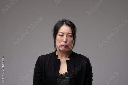 Foto Tearful sorrowful Asian woman grimacing