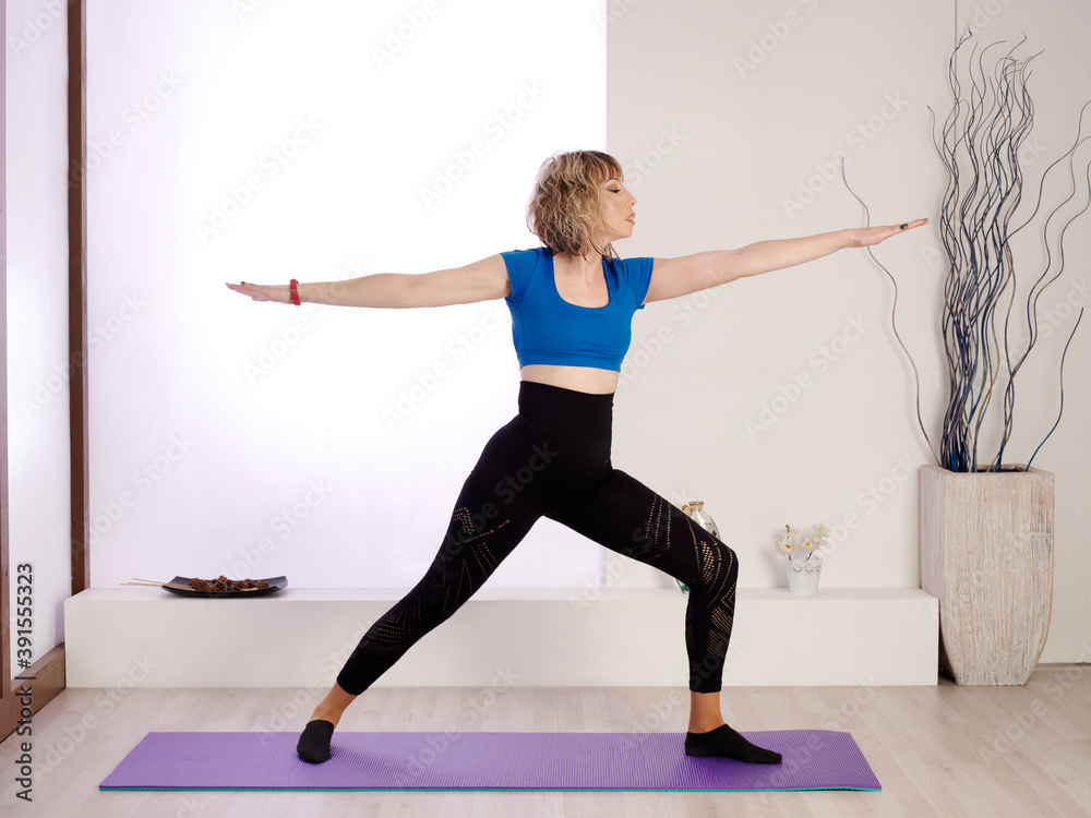 Young and pretty woman living a healthy life and practicing different Yoga exercises at home
