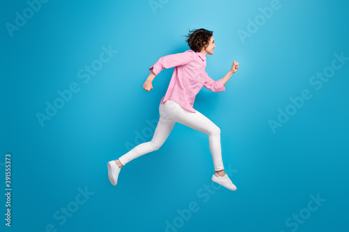 Full length photo of cheerful lady jump run fast copyspace isolated over blue pastel color background
