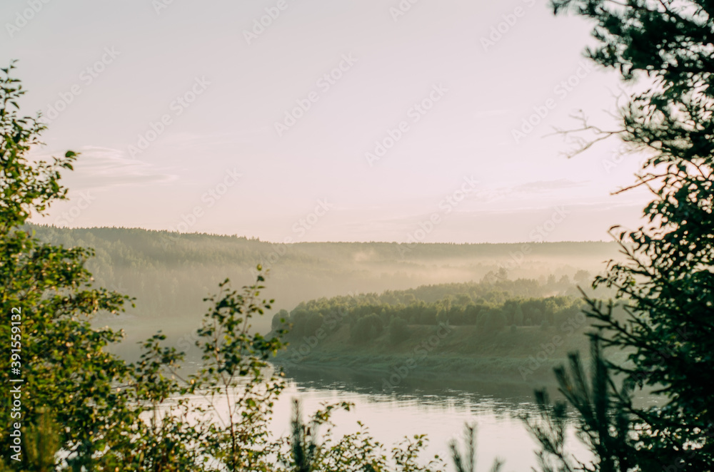 Thick fog on the autumn Bank of a wide river on a clear Sunny morning