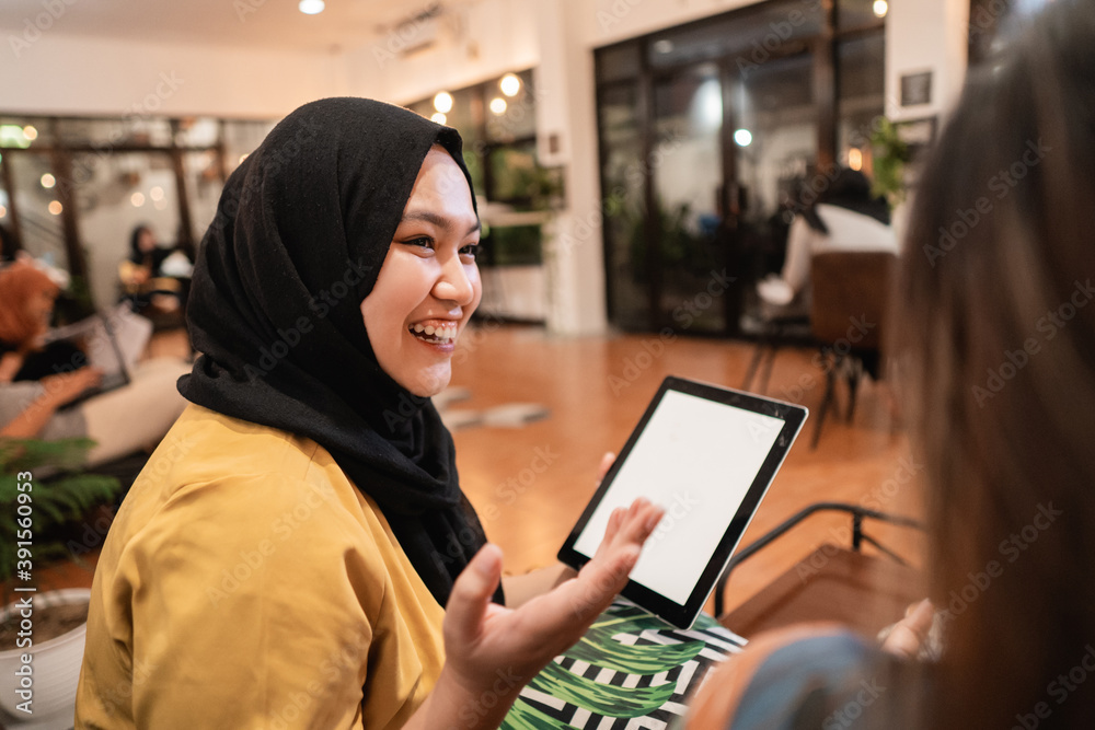 hijab girl using tablet when enjoy chatting together in the coffee shop hijab girl using tablet when enjoy chatting together in the coffee shop