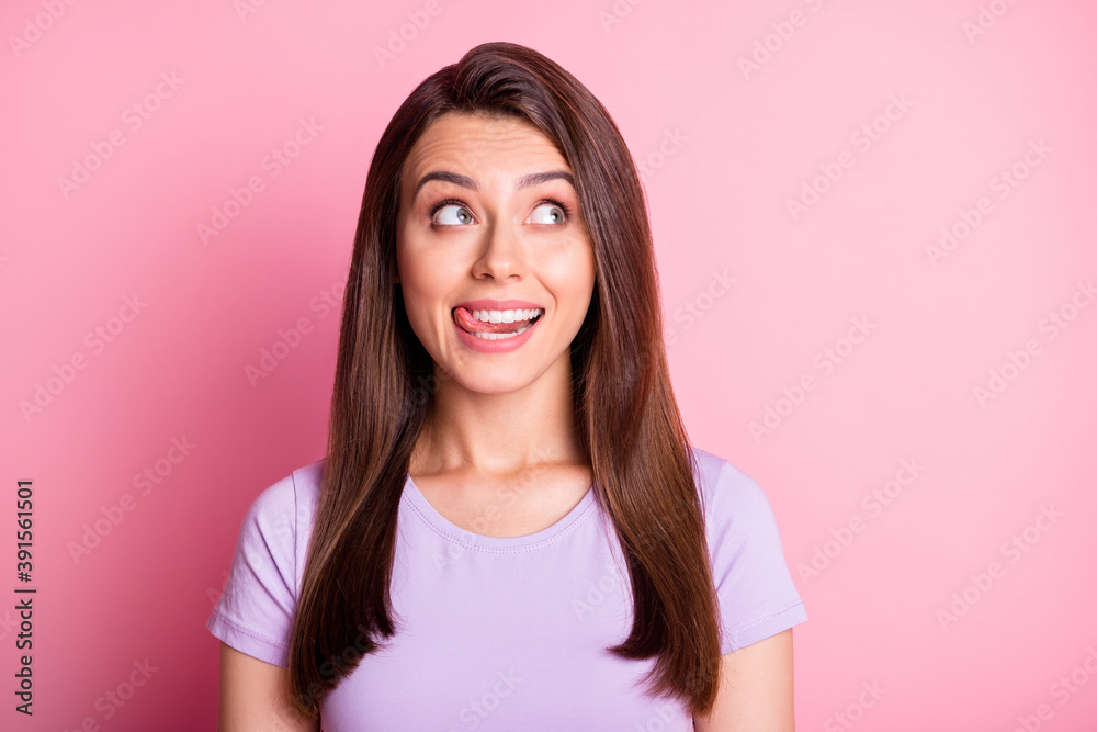 Photo portrait of dreamy brunette looking up at copyspace showing tongue licking hungry isolated on pastel pink color background Photo portrait of dreamy brunette looking up at copyspace showing tongue licking hungry isolated on pastel pink color background