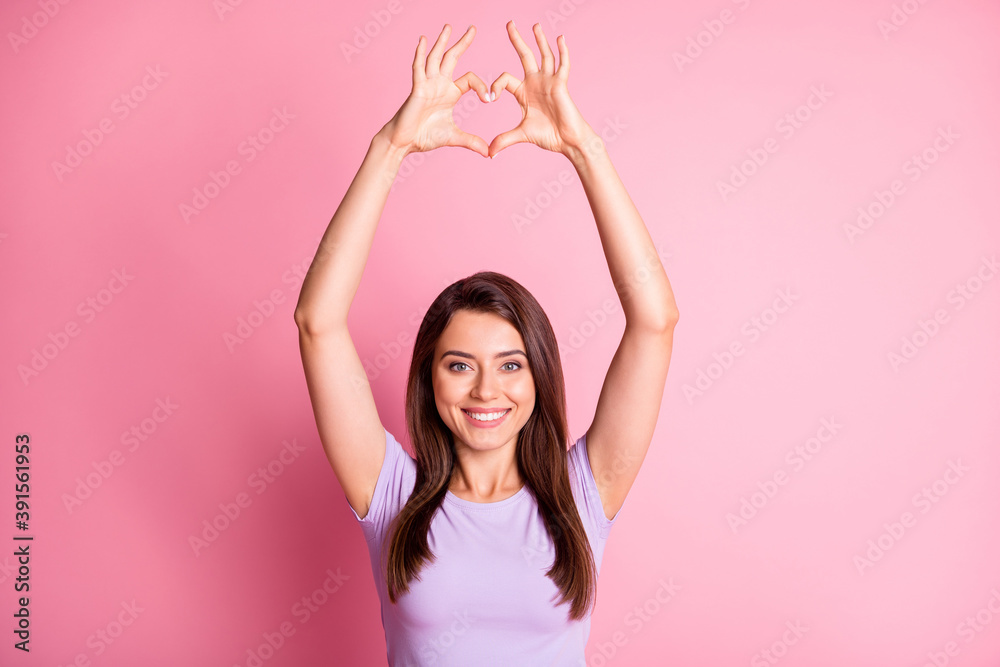 Photo portrait of beautiful girlfriend showing heart with fingers on saint valentines day isolated on pastel pink color background Photo portrait of beautiful girlfriend showing heart with fingers on saint valentines day isolated on pastel pink color background