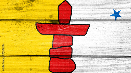 nunavut flag painted on old wood plank background. Brushed natural light knotted wooden board texture. Wooden texture background flag of nunavut