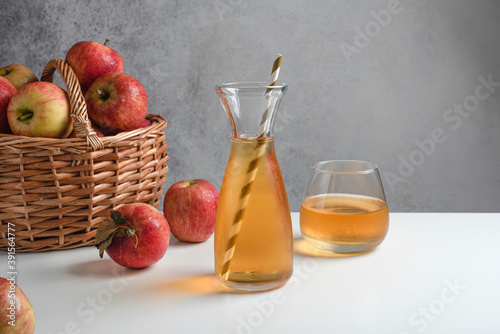 Glass of apple juice with red apples on a wooden table, close up. White background. Copy place. Horizontal
