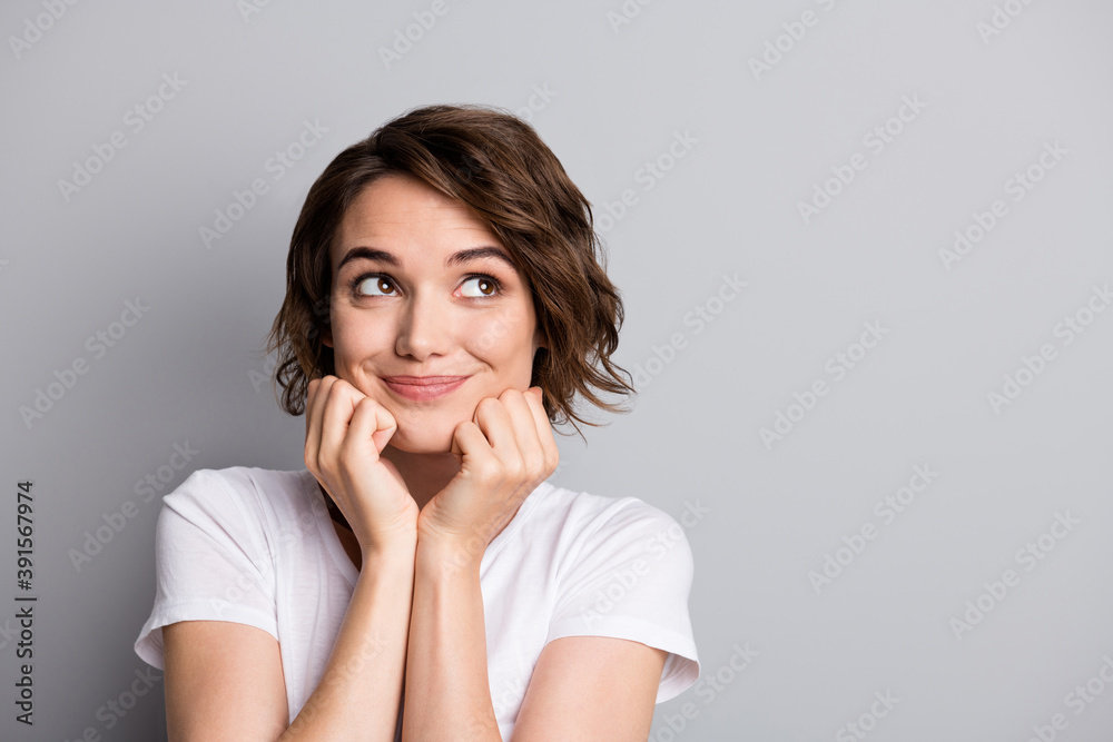 Photo of young cute girl wear casual outfit hands touch cheeks look empty space isolated over grey color background Photo of young cute girl wear casual outfit hands touch cheeks look empty space isolated over grey color background
