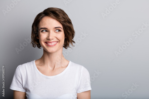 Portrait of young happy smiling charming woman girl female look in copyspace isolated on grey color background