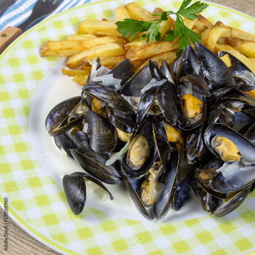 assiette de moules cuisinées et frites sur une table