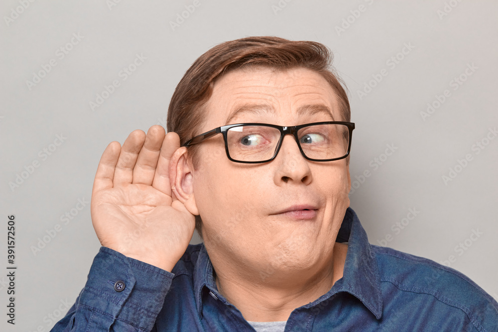 Portrait of curious man placing hand near ear and eavesdropping Portrait of curious man placing hand near ear and eavesdropping