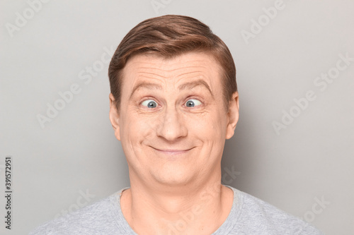 Portrait of funny happy man making goofy face with crossed eyes