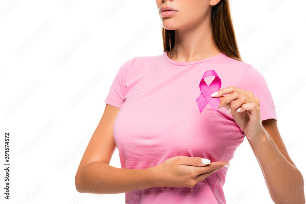 Cropped view of young woman showing breast cancer awareness ribbon while touching breast isolated on white Cropped view of young woman showing breast cancer awareness ribbon while touching breast isolated on white