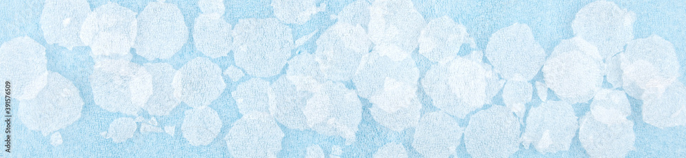 White round plastic foam sheet pieces on blue background. Winter snowfall concept. Torn foam polyethylene transparent pieces as snowflakes. White round plastic foam sheet pieces on blue background. Winter snowfall concept. Torn foam polyethylene transparent pieces as snowflakes.