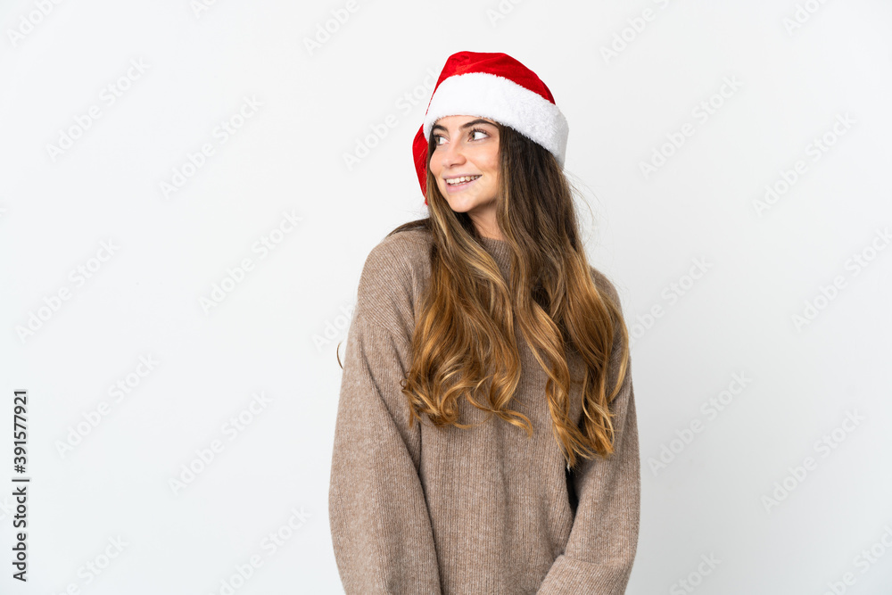 Caucasian girl with christmas hat isolated on white background looking to the side and smiling