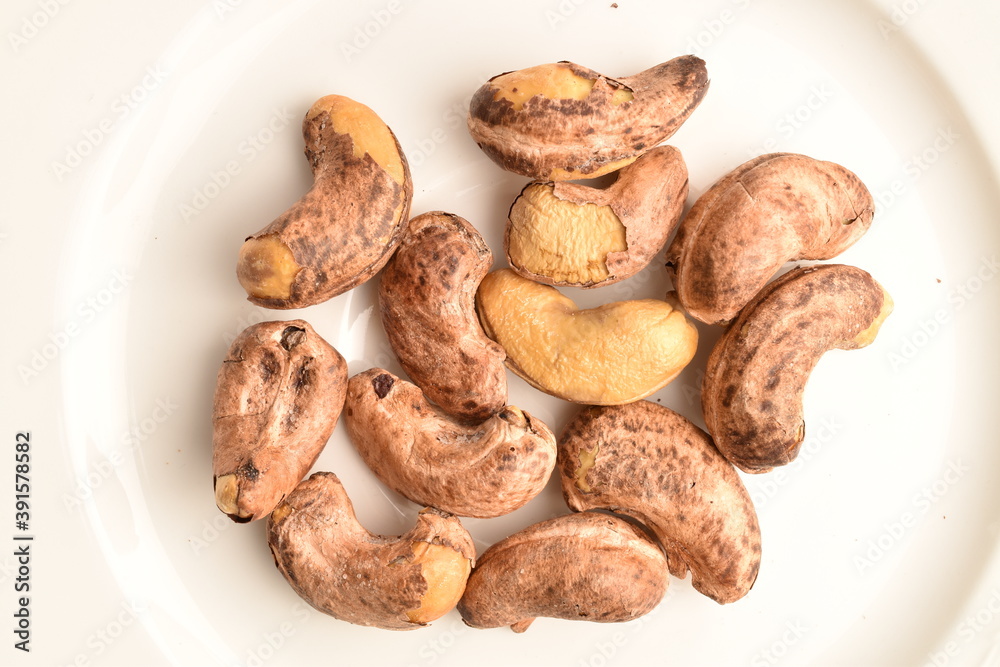 Fragrant fried salted cashews, close-up, on a white ceramic dish. Fragrant fried salted cashews, close-up, on a white ceramic dish.