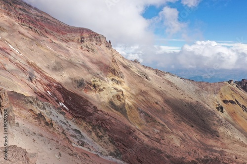 Mountain slope at a high altitude showing the red  yellow  grey and white vulcanic substrate of the chimborazo vulcano in Ecuador