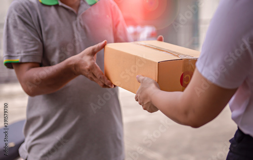 Delivery man by sending box of parcel to customers service at home