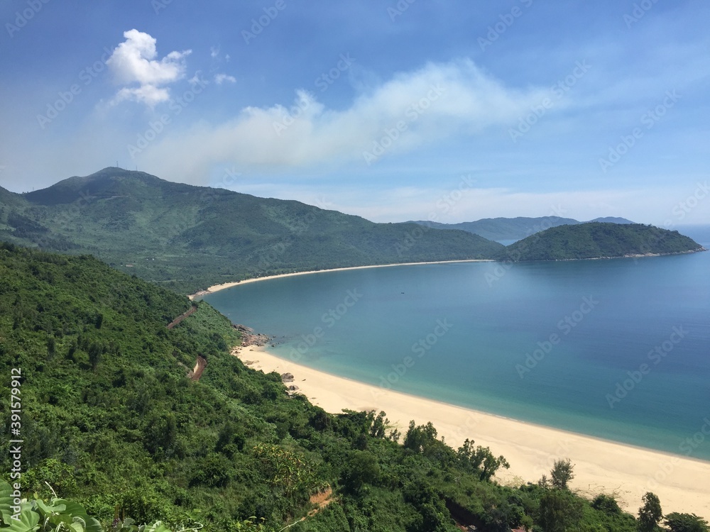 Heaven on earth, a sandy, yellow beach alongside a hill covered in rainforest
