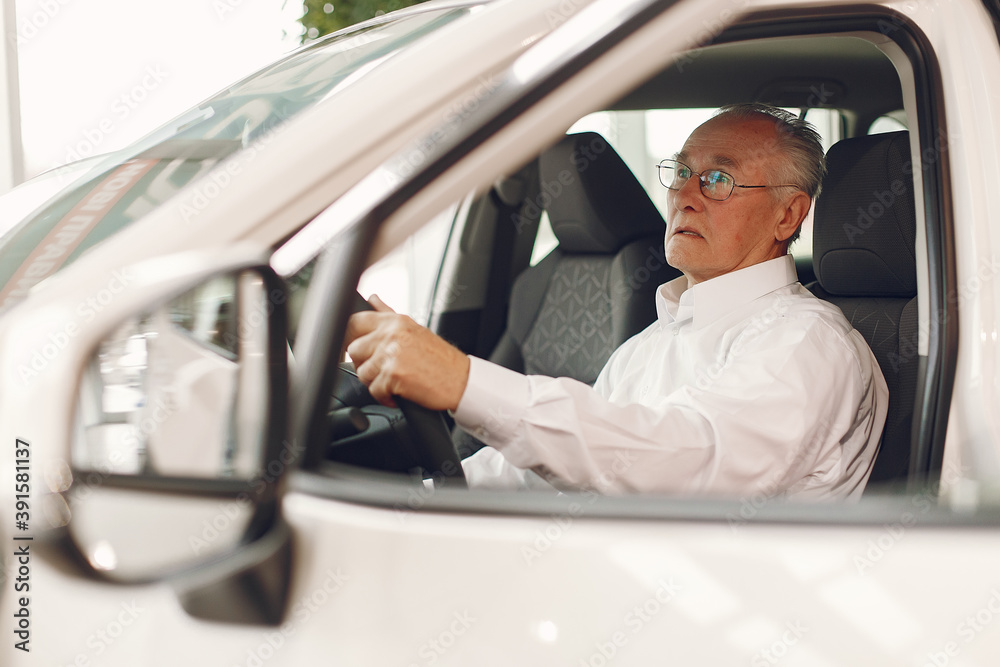 Old man in a car salon. Senior buying the car. Grandfather by a car. Old man in a car salon. Senior buying the car. Grandfather by a car.