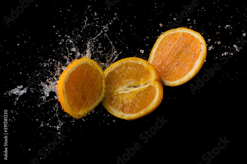 citrus fruits in water splash on black background