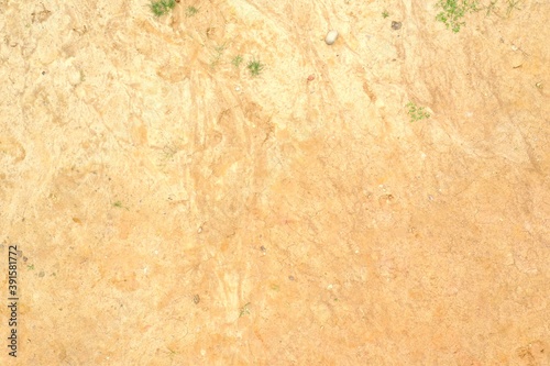 Texture of a dry sandbed in light yellow and orange colors