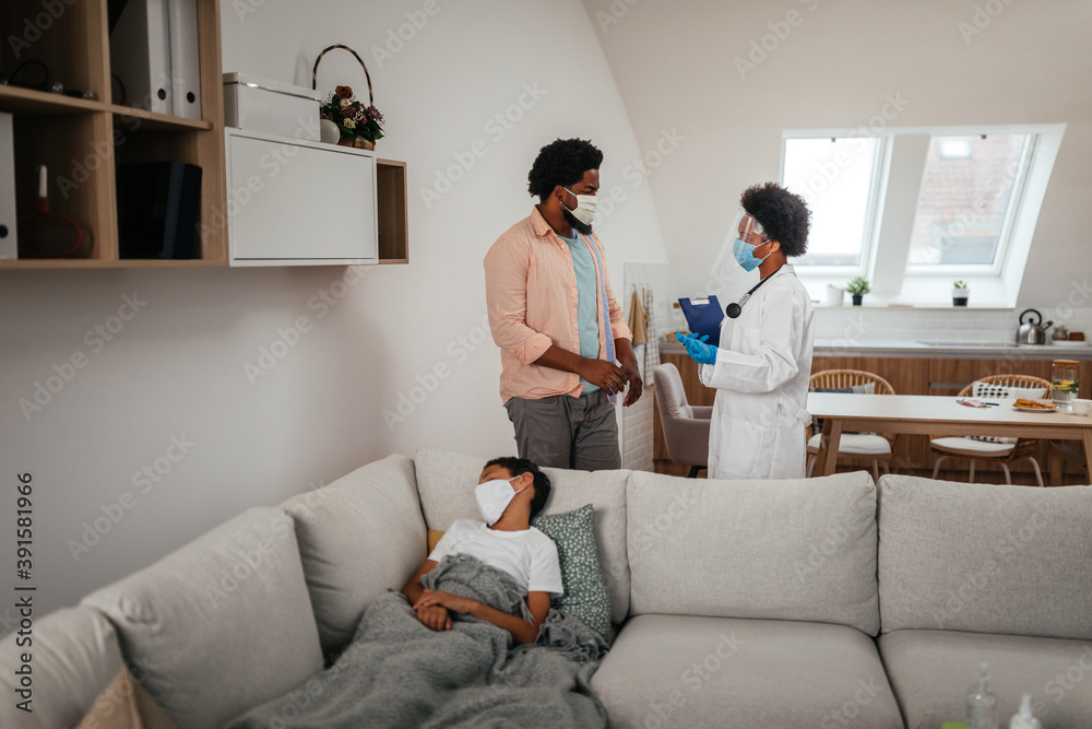 Obraz premium Female doctor visiting father and son at home