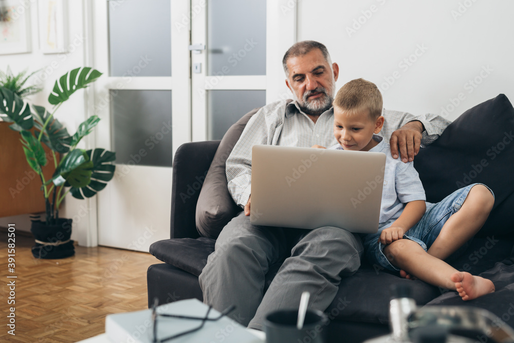 grandfather and his grandson using computer at home grandfather and his grandson using computer at home