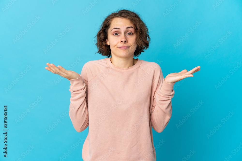 Young English woman isolated on blue background making doubts gesture Young English woman isolated on blue background making doubts gesture