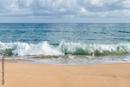 Surf rolls in on a Kauai beach © jimbennett