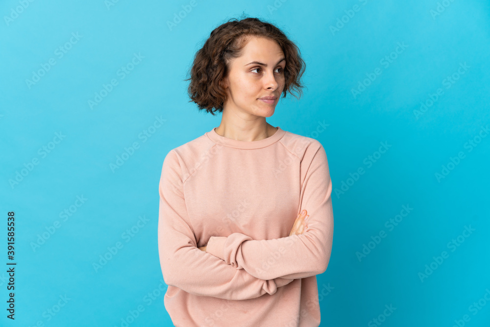 Young English woman isolated on blue background keeping the arms crossed Young English woman isolated on blue background keeping the arms crossed
