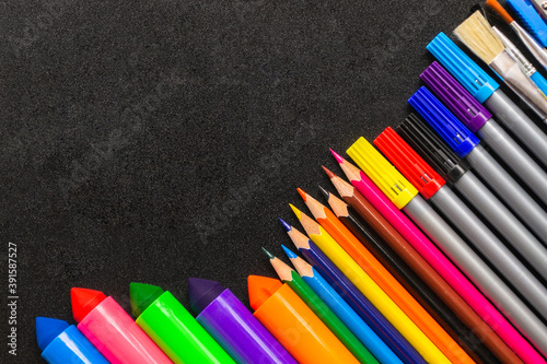 Frame from pencils and felt-tip pens on chalk background. Back to school and new academic year concept. Copy space, place for text.