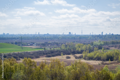 Forest and field top view. Aerial view to tops of trees and city in the background. Scenic landscape of Riga  Latvia.