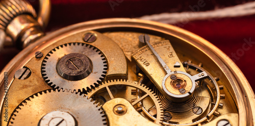100 years old original golden pocket watch close up red background
