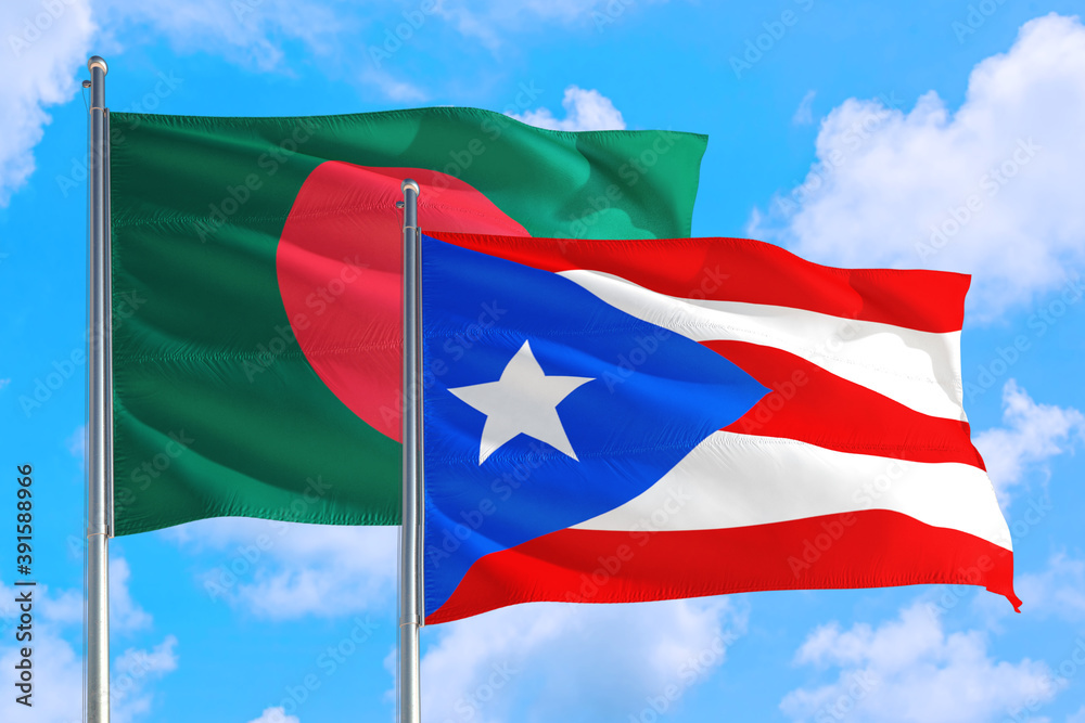 Puerto Rico and Bangladesh national flag waving in the windy deep blue sky. Diplomacy and international relations concept. Puerto Rico and Bangladesh national flag waving in the windy deep blue sky. Diplomacy and international relations concept.