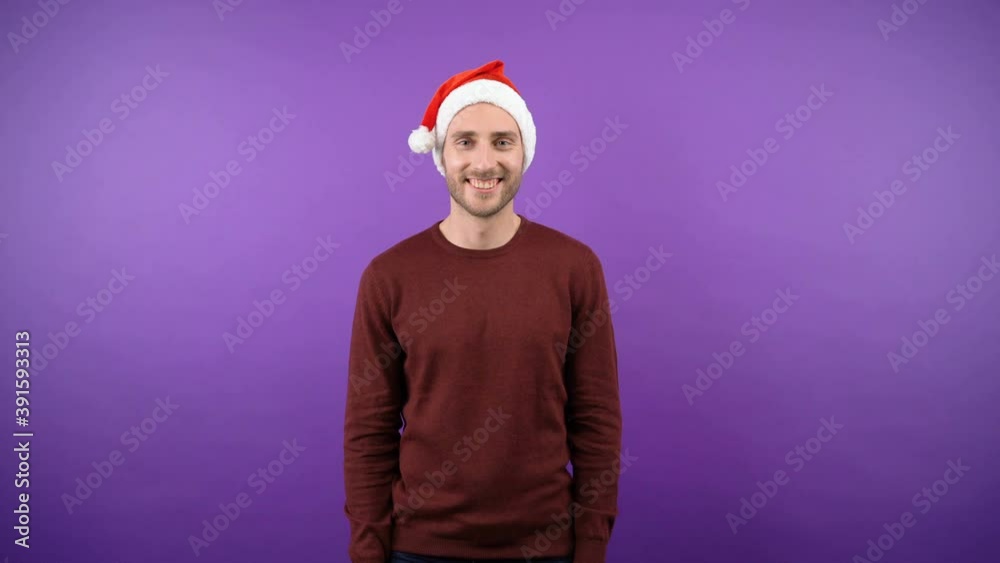 nice young attractive bearded man in christmas santa hat man over isolated purple background. 4K nice young attractive bearded man in christmas santa hat man over isolated purple background. 4K