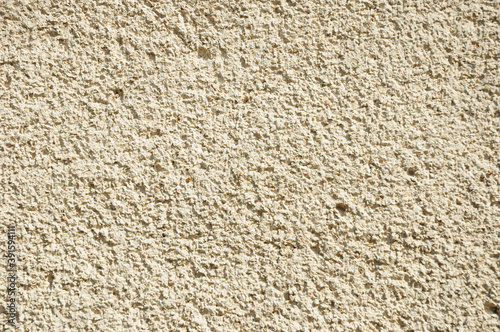 A close-up of a traditional stucco float sand finishing, heavy, fine dash finish stucco texture.