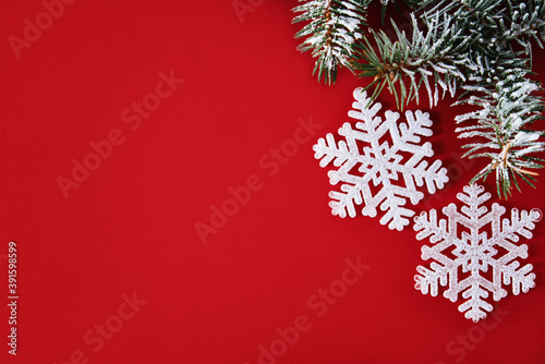 Christmas composition with white snowflake and christmas tree branch on red background  top view