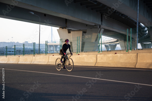 Evening workout of a woman on a bike. Play sports in the city. Yacht Bridge St. Petersburg.