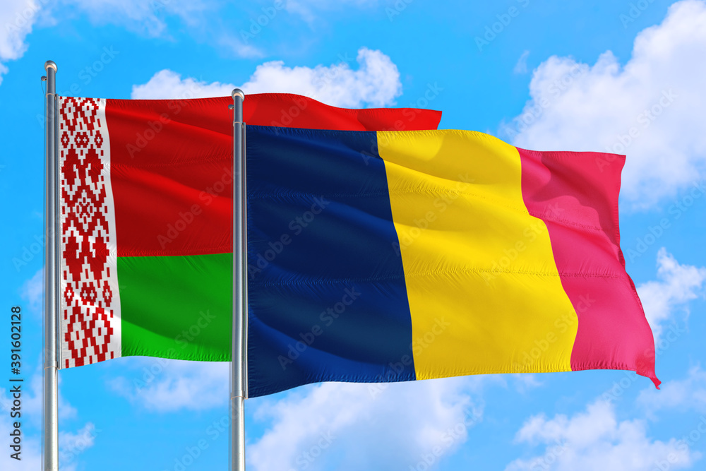 Obraz premium Chad and Belarus national flag waving in the windy deep blue sky. Diplomacy and international relations concept.