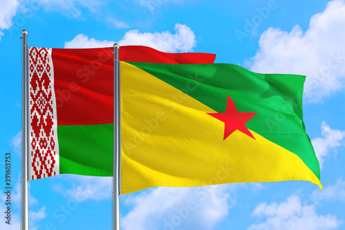 French Guiana and Belarus national flag waving in the windy deep blue sky. Diplomacy and international relations concept.