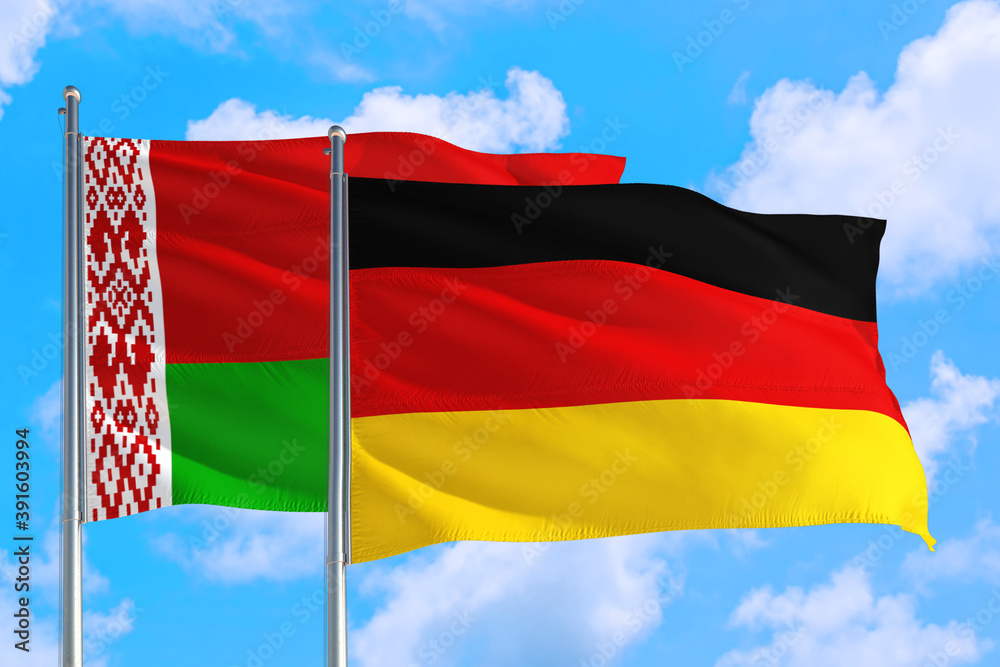 Germany and Belarus national flag waving in the windy deep blue sky. Diplomacy and international relations concept. Germany and Belarus national flag waving in the windy deep blue sky. Diplomacy and international relations concept.