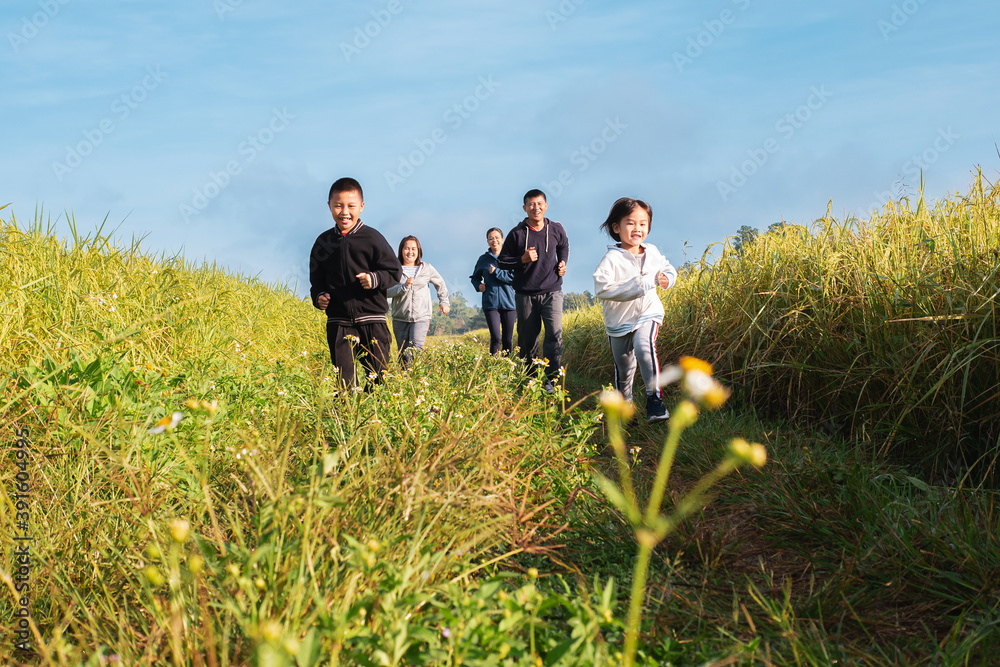 Small group of people multigeneration Asian family jogging together, outdoor morning run in nature trail organic rice paddy field. Healthy lifestyles and sustainability concepts. Small group of people multigeneration Asian family jogging together, outdoor morning run in nature trail organic rice paddy field. Healthy lifestyles and sustainability concepts.