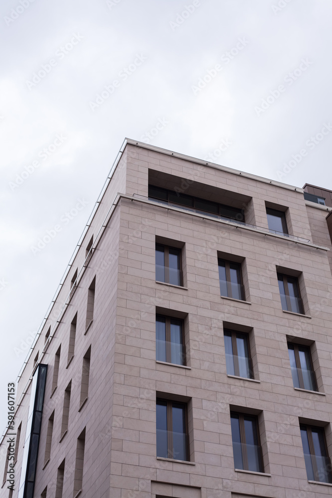 A minimalistic gray building in the center of Moscow. The sky is reflected in the windows in blue