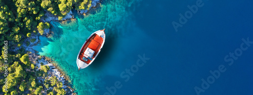 Aerial drone ultra wide panoramic photo of traditional wooden fishing boat anchored in Ionian island turquoise sea, Greece
