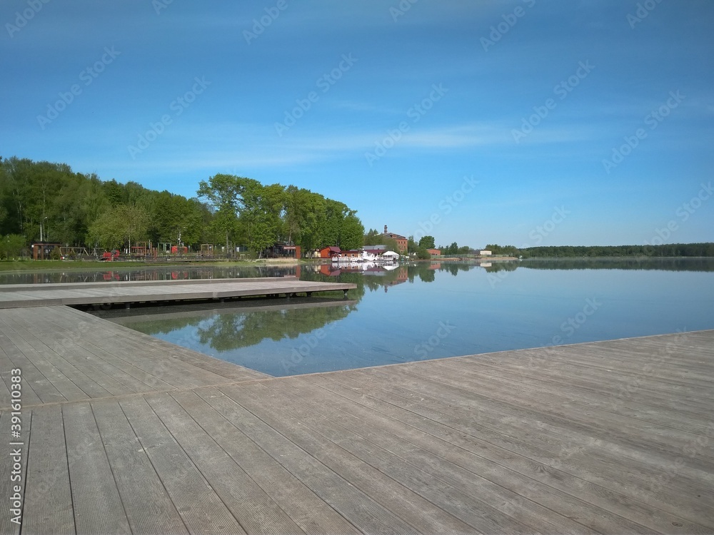 Beautiful blue lake river and wooden deck in summer against the background of blue sky and green trees
lake Senezh in Solnogorsk on a summer sunny day
wooden pier on the lake