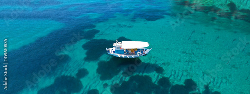 Aerial drone ultra wide panoramic photo of traditional wooden fishing boat anchored in Ionian island turquoise sea, Greece © aerial-drone