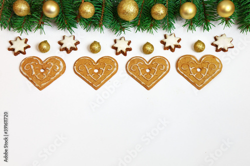 Bożonarodzeniowa dekoracja złożona z gałązek świerku i pierników na białym tle