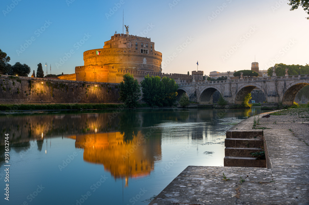 Night to sunrise long exposure of Castel Sant’Angelo (Castle of the Holy Angel), an ancient tomb and fortress, illuminated at night and reflecting on the Tiber river, with the Bridge of the Holy Angel