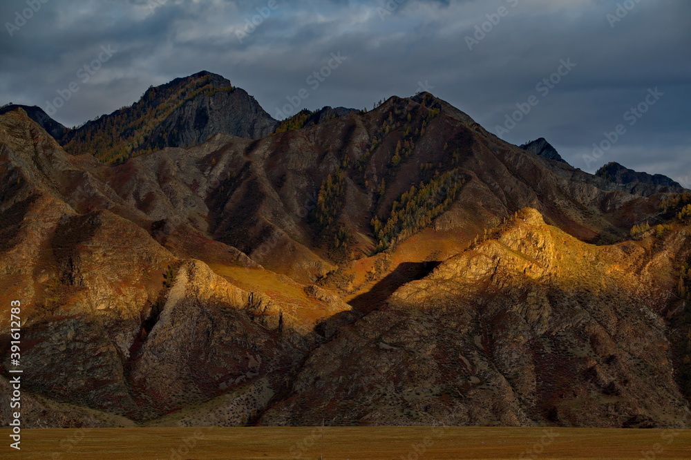 Fototapeta premium Russia. Mountain Altai. Illuminated by the sunset rays of the sun, the picturesque mountains along the Chui tract near the village of Inya.