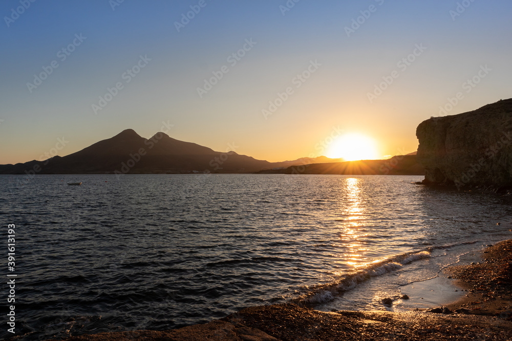 Sunset by the sea, Mediterranean landscape at the coast, sun reflected at the beach. Cabo de Gata, Almería, Andalusia, South of Spain
